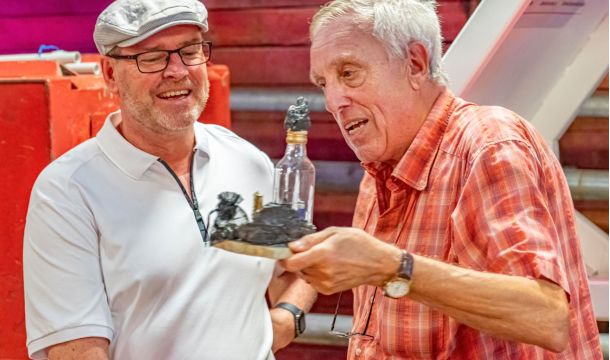 Bei seinem Besuch des Knappenvereins Tecklenburger Land hat ihm Fritz Raßmann (l.), ehemaliger Leiter des Bezirks Ibbenbüren der IGBCE, einen Miniatur-Bergmann mit Grubenlampe und einem Miniatur-Jürgen Coße mit SPD-Schild in einer Flasche geschenkt.