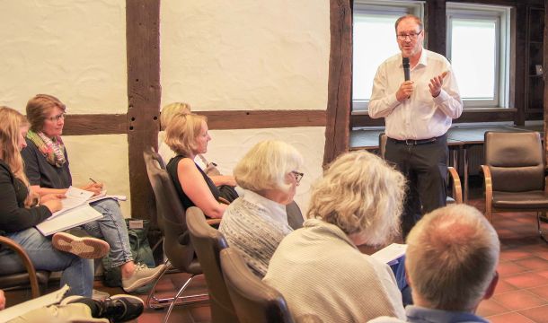 Jürgen Coße (stehend) während des Arbeitsgesprächs im Haus des Gastes in Lienen