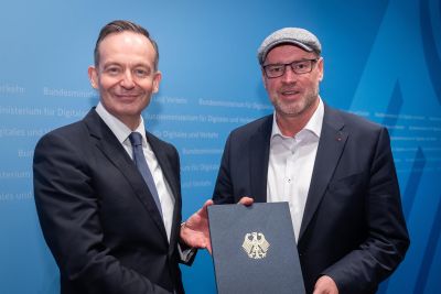 Bei der feierlichen Übergabe am Donnerstag in Berlin hat Verkehrsminister Dr. Volker Wissing (l.) an den Bundestagsabgeordneten für das nördliche Münsterland, Jürgen Coße (r.), die Förderurkunde aus dem sogenannten Bodenstrom-Programm überreicht. Foto: BMDV, Sebastian Woithe